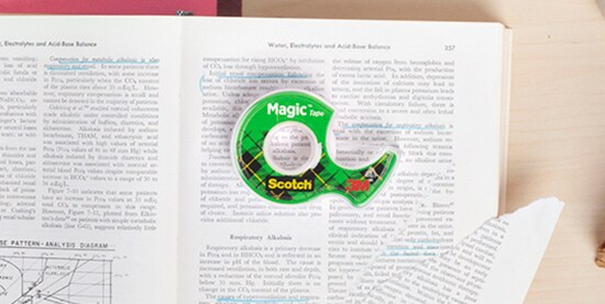 Cintas Mágica Scotch sobre un libro mostrando modo de uso.
